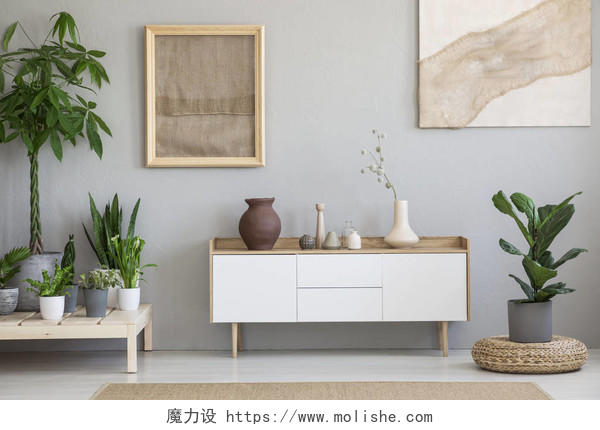 在客厅白色橱柜上面的灰色墙上贴着植物和脚凳的